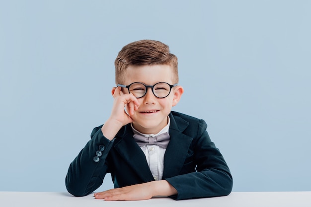 Niño lindo con gafas y un traje negro