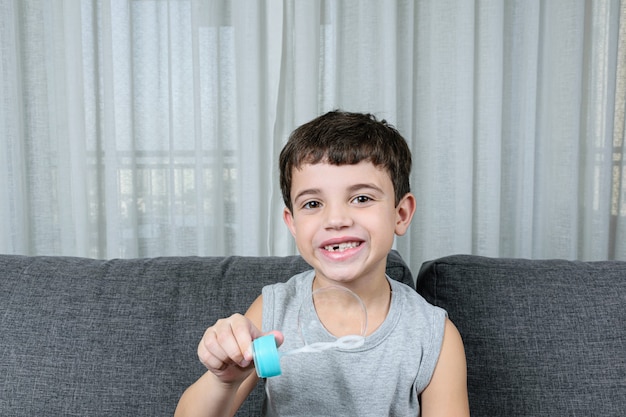 Niño lindo haciendo pompas de jabón