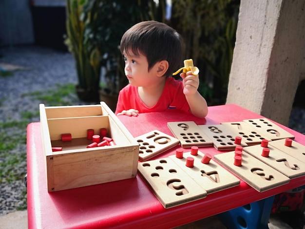Un niño lindo jugando con juguetes en la mesa.