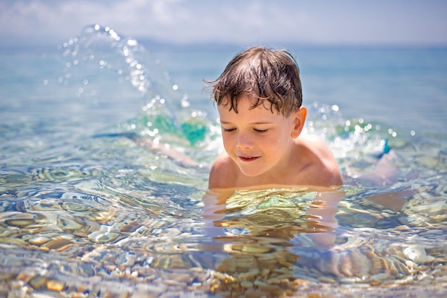 Foto niño lindo jugando en el mar