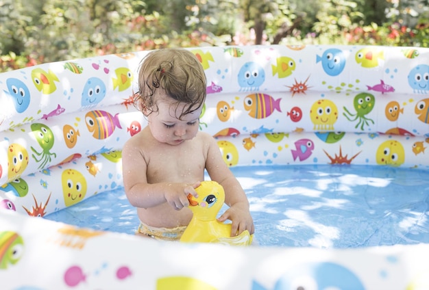 Niño lindo jugando en la piscina