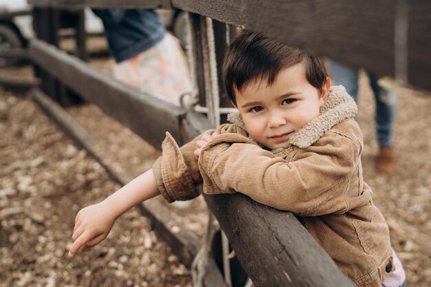 Foto niño lindo está mirando a la cámara en el campo infancia en la granja