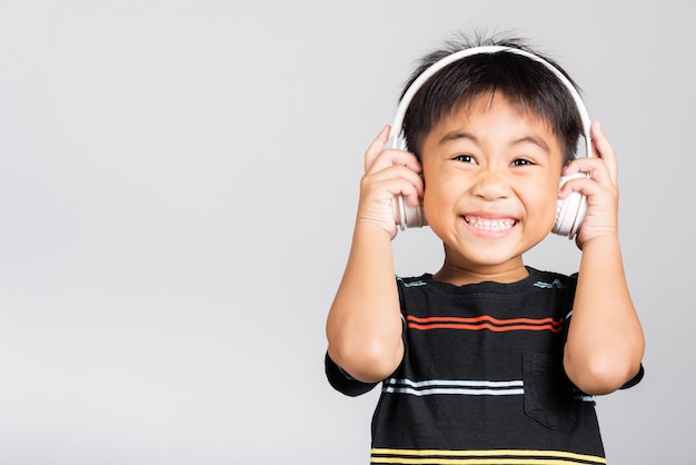 Niño lindo niño escucha música usa auriculares inalámbricos