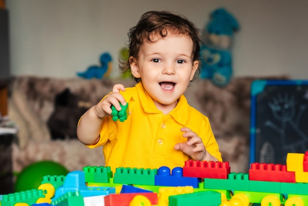 Niño lindo niño jugando en casa con cubos de colores