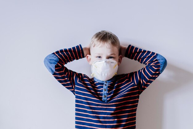 Niño lindo de pie contra un fondo gris