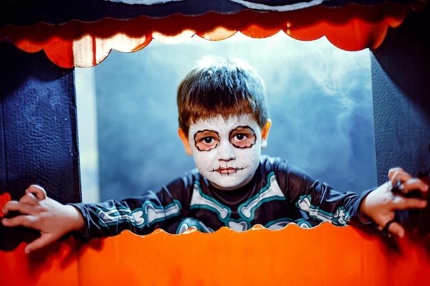 Foto niño lindo con pintura facial como esqueleto para celebrar halloween