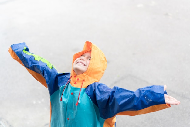 Niño lindo para probar la lluvia