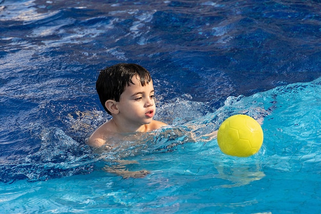 Niño lindo relajándose en la piscina