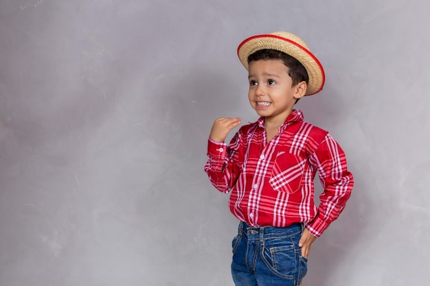 Foto un niño lindo con ropa típica de festa junina con espacio para copiar