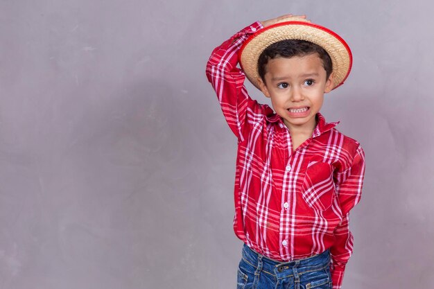 Un niño lindo con ropa típica de Festa Junina con espacio para copiar