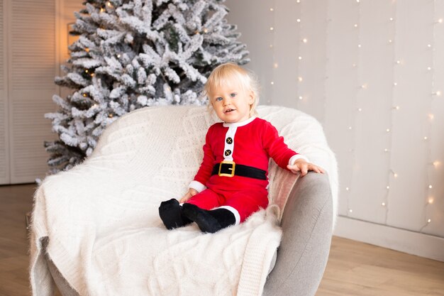 Niño lindo en sala decorada festiva para Navidad