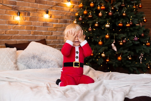 Niño lindo en sala decorada festiva para Navidad