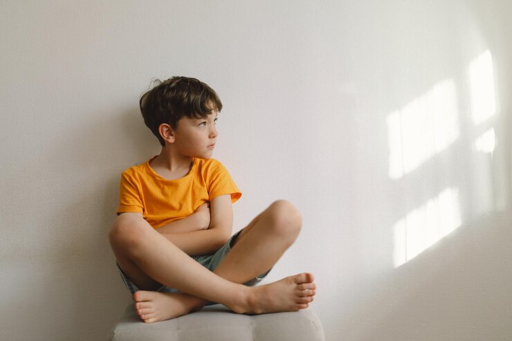 Niño lindo sentado descalzo en una casa de hermosa luz