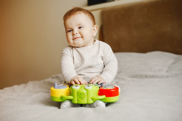 niño lindo sentado y jugando en casa