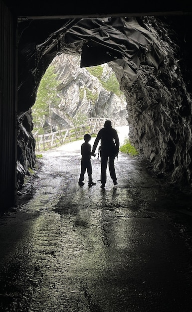 Niño con madre en cueva oscura en las montañas