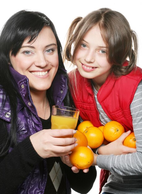 Niño con madre sosteniendo naranjas y jugo