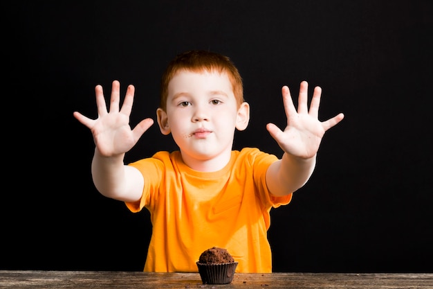 niño con una magdalena de chocolate