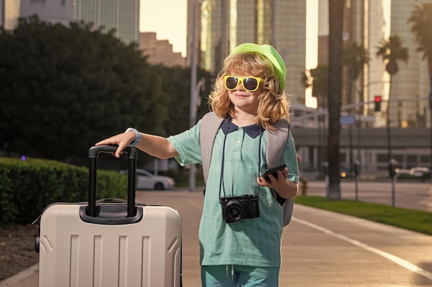 Niño con maleta de viaje de vacaciones Concepto de viaje y aventura para niños Niño niño que se va de vacaciones con equipaje bolsa de viaje al aire libre