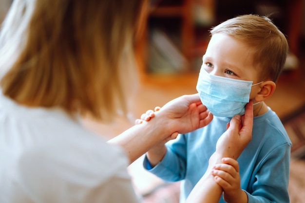 Foto niño y mamá en máscara médica.