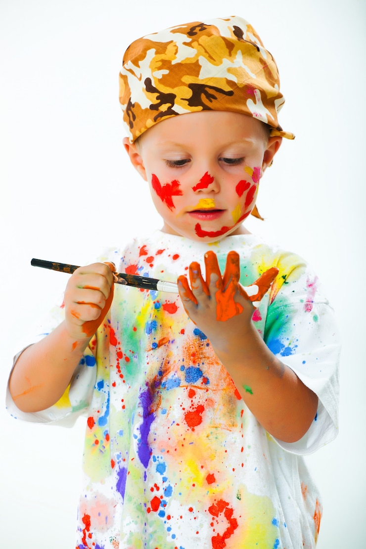 Foto niño manchado en dibujos de pintura