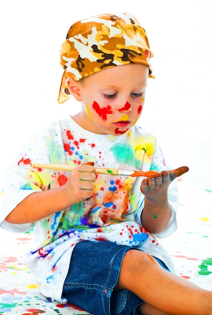 Niño manchado en dibujos de pintura