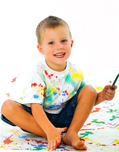 Niño manchado en dibujos de pintura