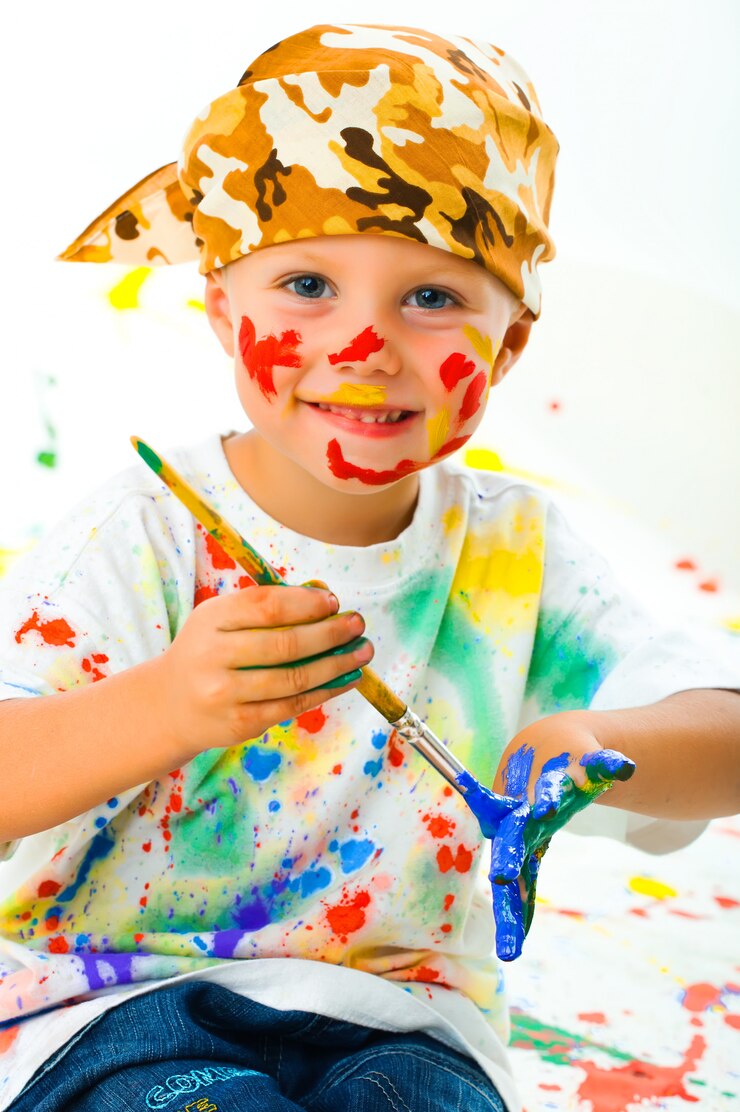 Foto niño manchado en dibujos de pintura