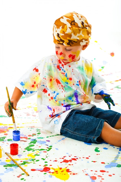 Foto niño manchado en dibujos de pintura