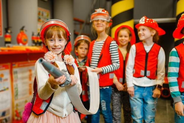 Foto niño con manguera en manos jugando bombero