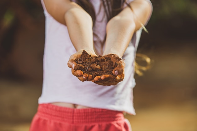 Niño mano sujetando el suelo, prepárate para plantar el árbol