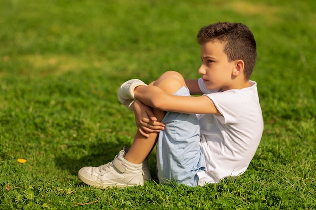 Niño con mano vendada y yeso al aire libre