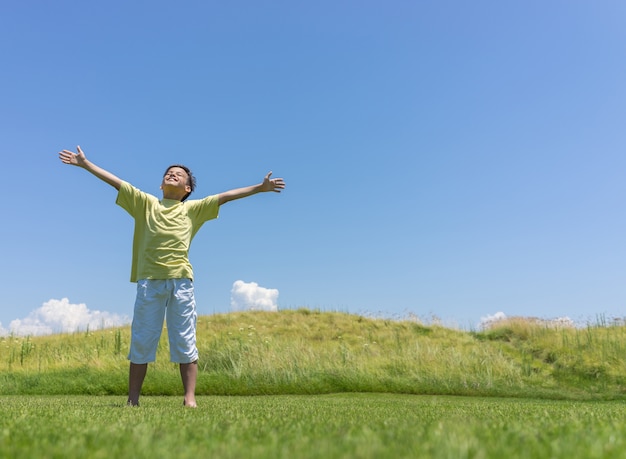 Niño con las manos abiertas en la hermosa naturaleza