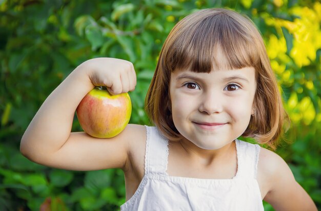 Foto niño con una manzana. enfoque selectivo naturaleza