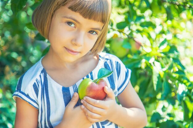 Niño con una manzana en el jardín