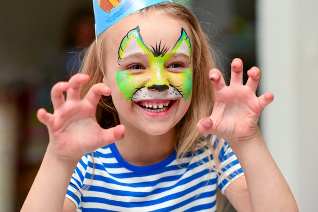 Niño en maquillaje gruñe con garras manos