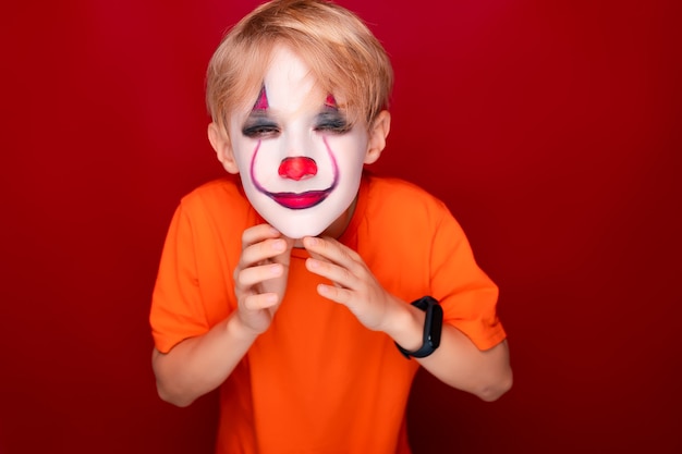 Niño con maquillaje de halloween tiene las manos delante de él.