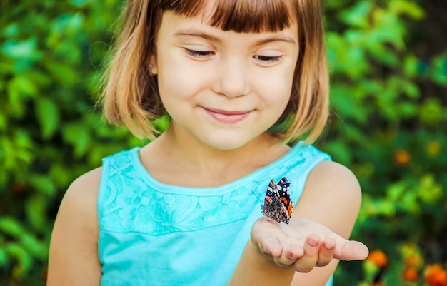 Niño con una mariposa. Enfoque selectivo naturaleza.