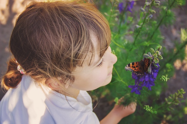 Niño con una mariposa. Idea leuconoe. Enfoque selectivo