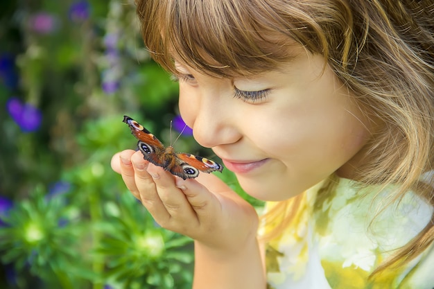 Niño con una mariposa en sus manos.