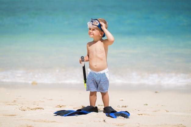 Niño con máscara de buceo y aletas ir a nadar en la playa