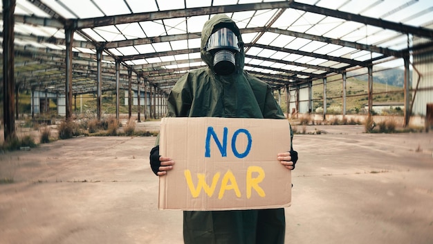 Niño con máscara de gas sostiene cartón en la mano sin texto de guerra