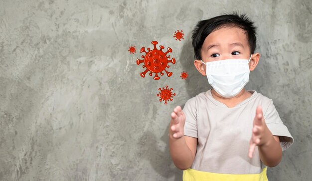 Foto niño con máscara de pie contra la pared