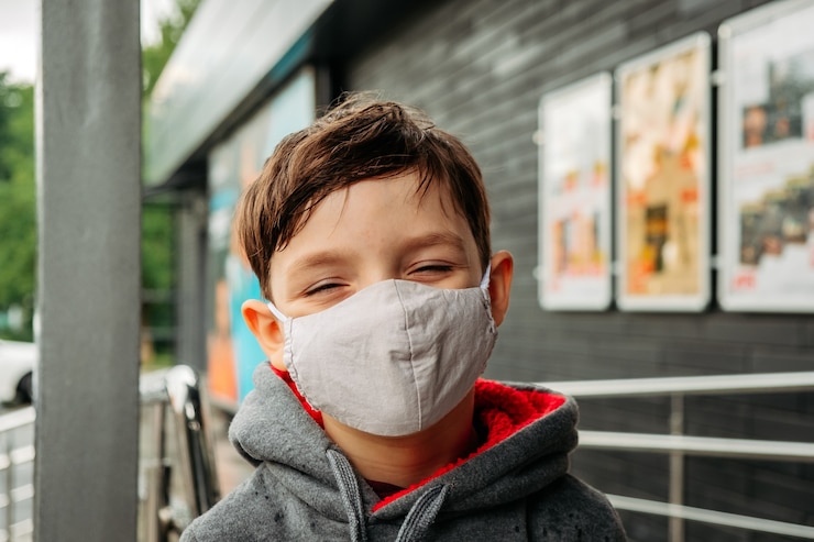 Foto un niño con una máscara protectora entra al supermercado.