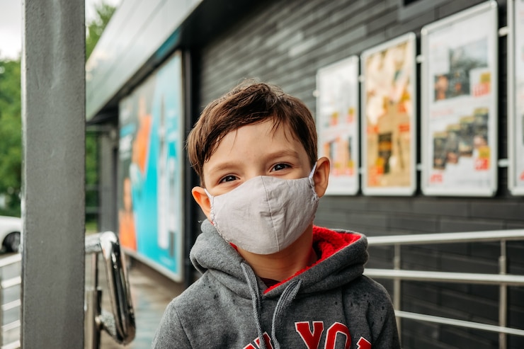 Foto un niño con una máscara protectora entra al supermercado.