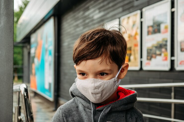 Foto un niño con una máscara protectora entra al supermercado.