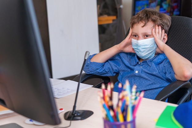 Niño con máscara protectora haciendo su tarea