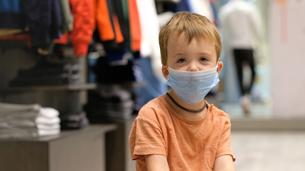 Niño con una máscara protectora en una tienda