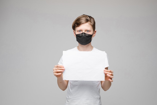 Niño con mascarilla con cartel en blanco