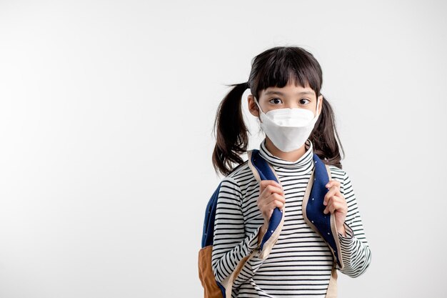 Niño con mascarilla que regresa a la escuela después de la cuarentena y el encierro del covid-19.