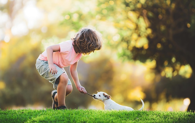 Niño con mascotas perro lindo niño y cachorro jugando afuera